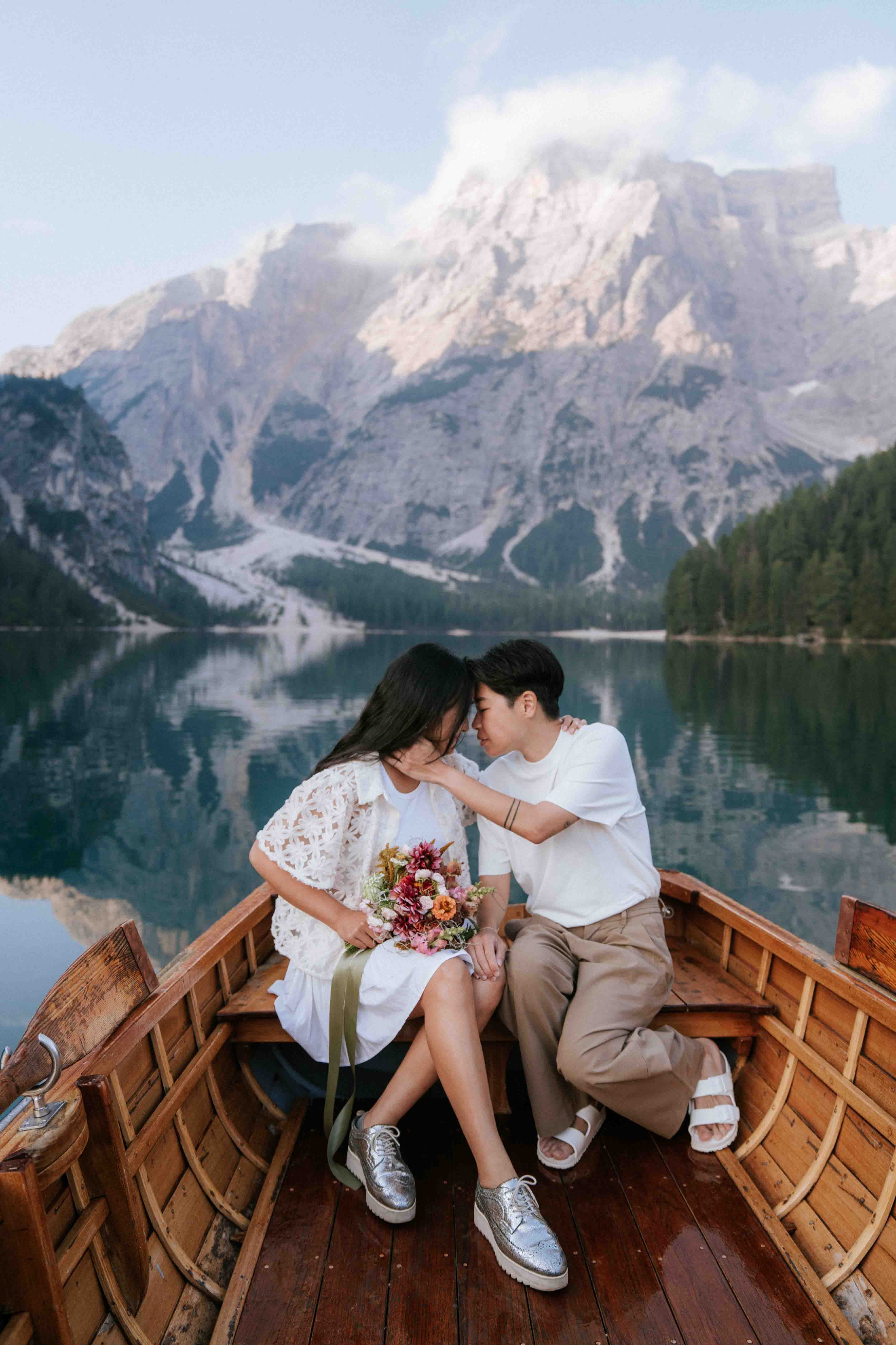 Couple portrait session at Lago di Braies with the iconic wooden boats and Dolomite peaks