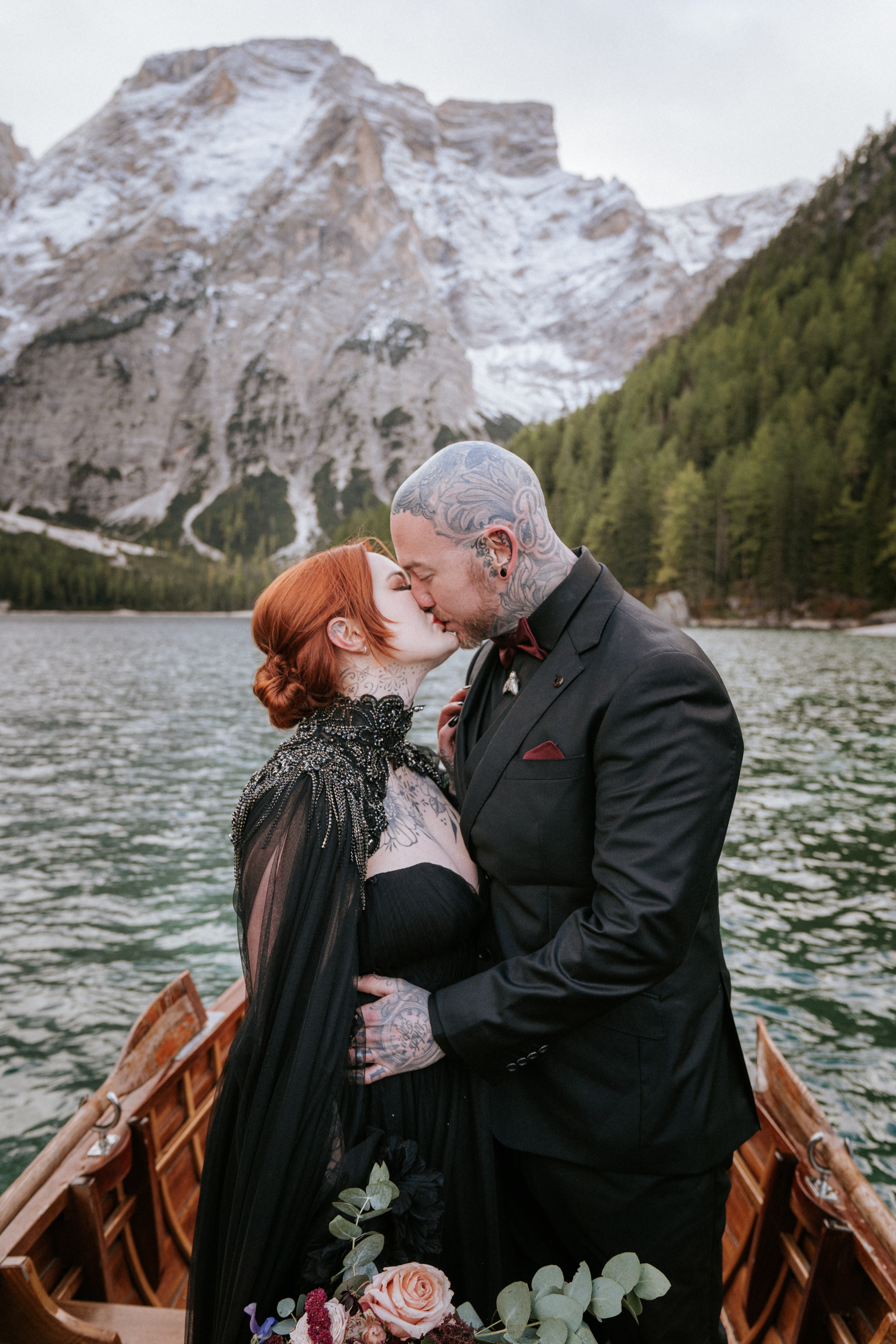 Couple sharing a tender moment at the boathouse dock at Lago di Braies – intimate elopement South Tyrol