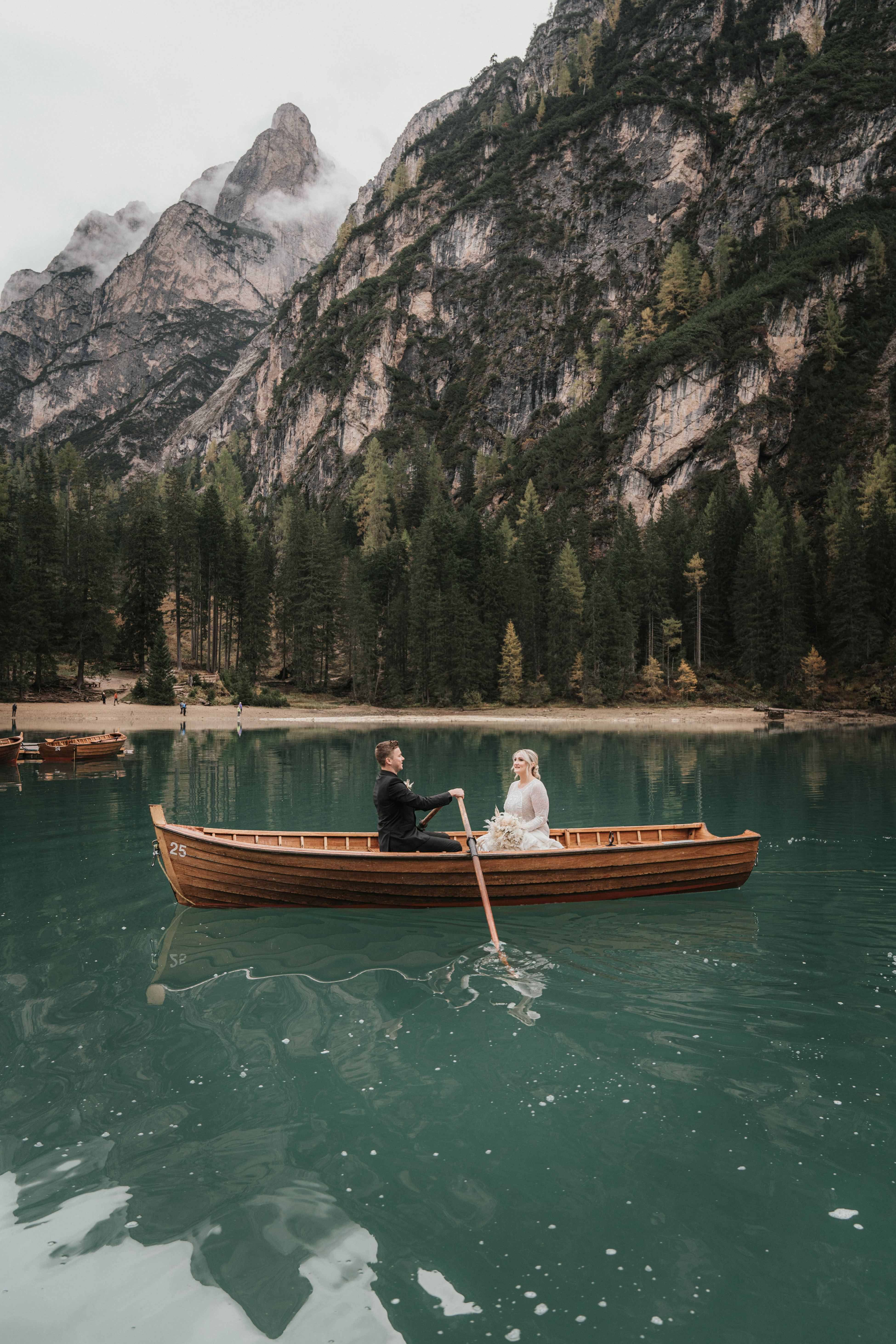 Couple exchanging vows on the wooden dock at Lago di Braies – intimate elopement ceremony with Dolomite reflection