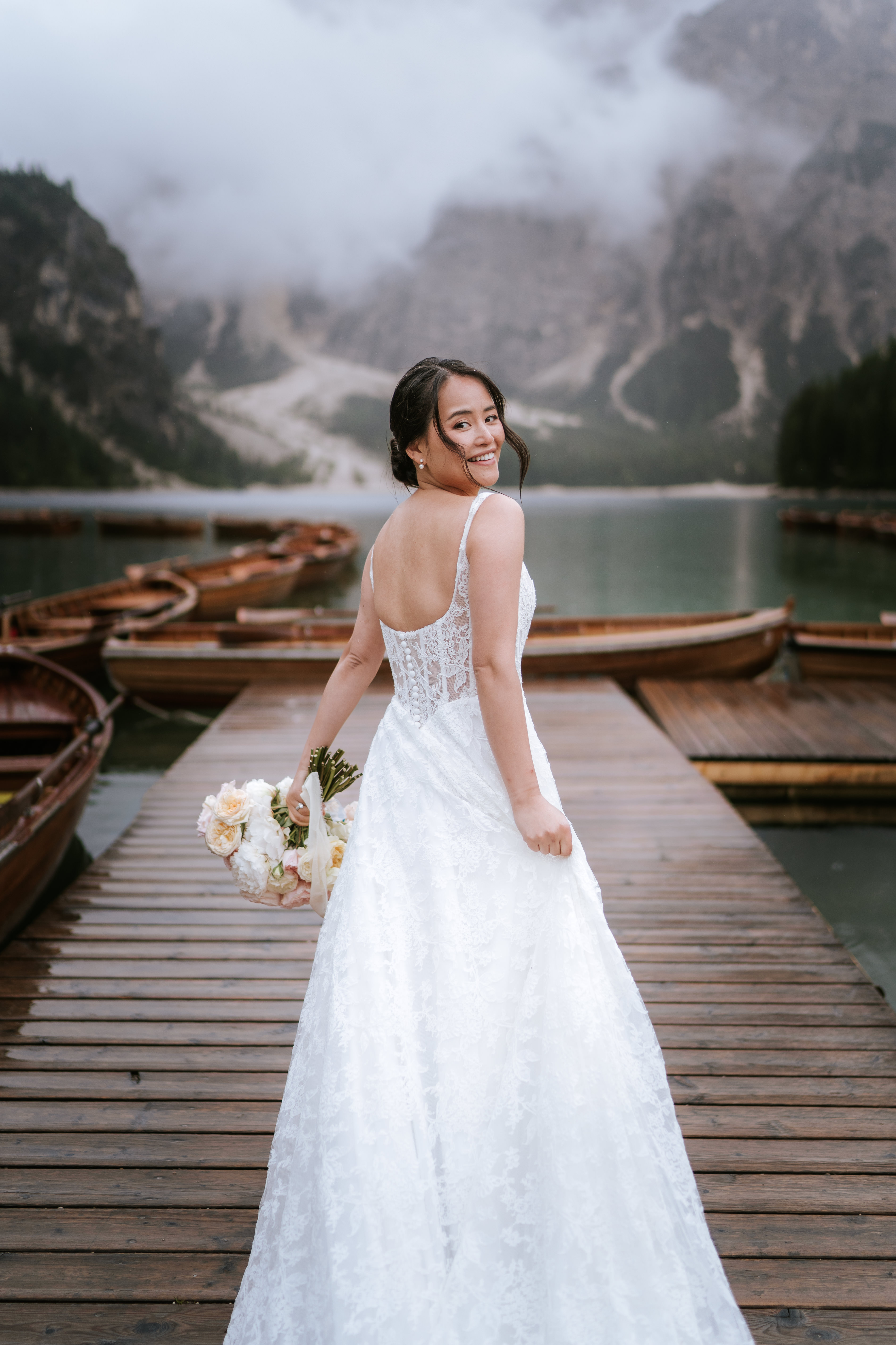 Couple walking hand in hand at Lago di Braies in the rain – elopement in all weather, South Tyrol Dolomites