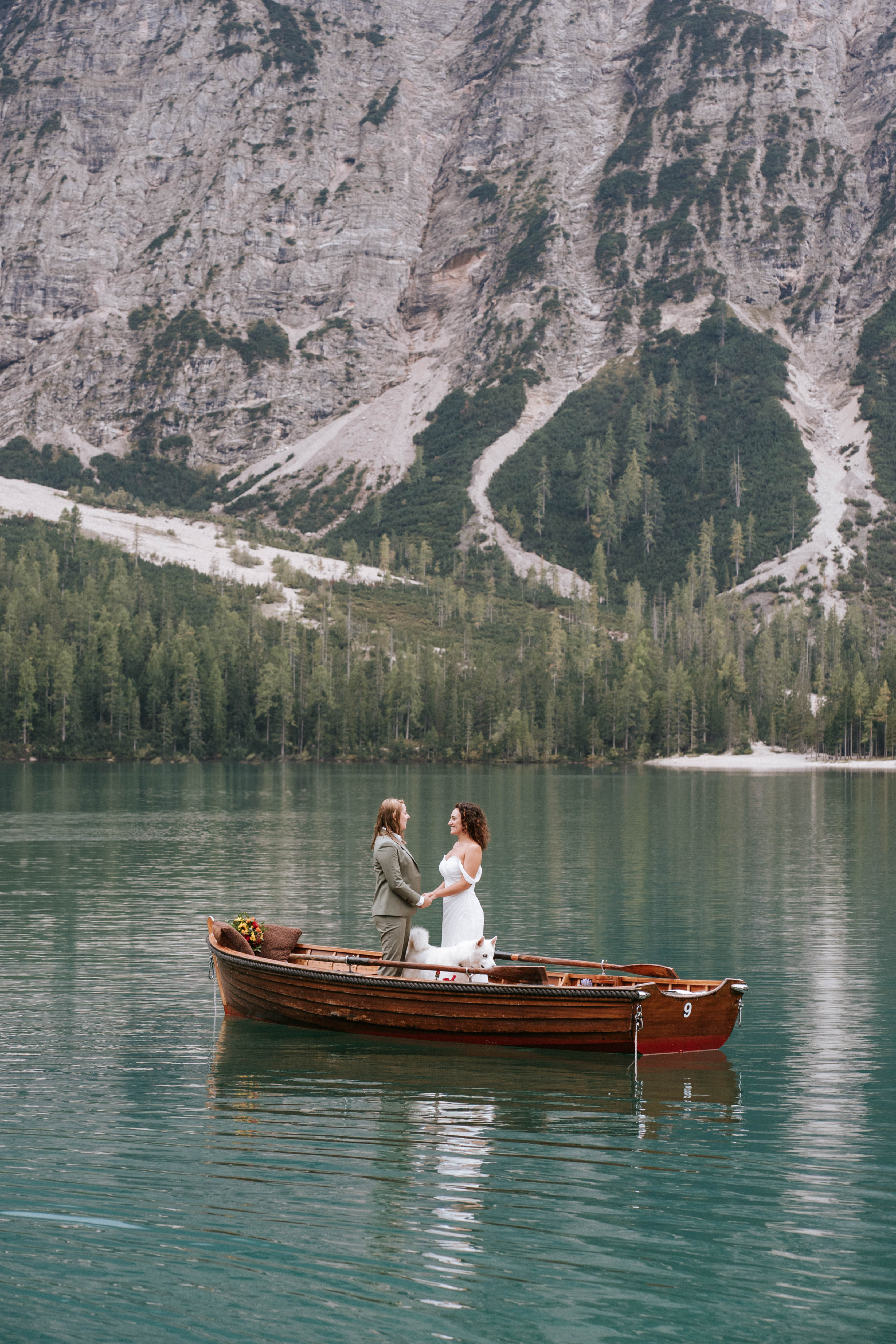 Couple walking along the shore of Lago di Braies with the Dolomite peaks towering above – elopement photographer South Tyrol